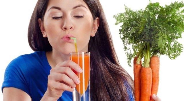 Женщина пьет морковный сок