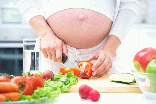 беременная режет овощи